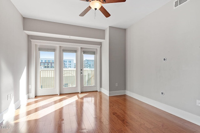 empty room with ceiling fan and light hardwood / wood-style flooring