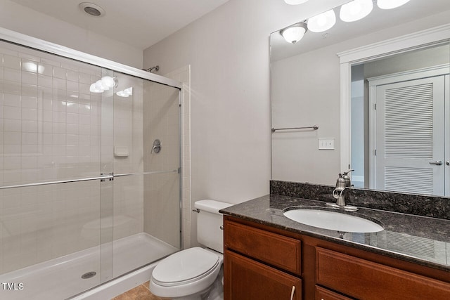 bathroom with an enclosed shower, vanity, and toilet