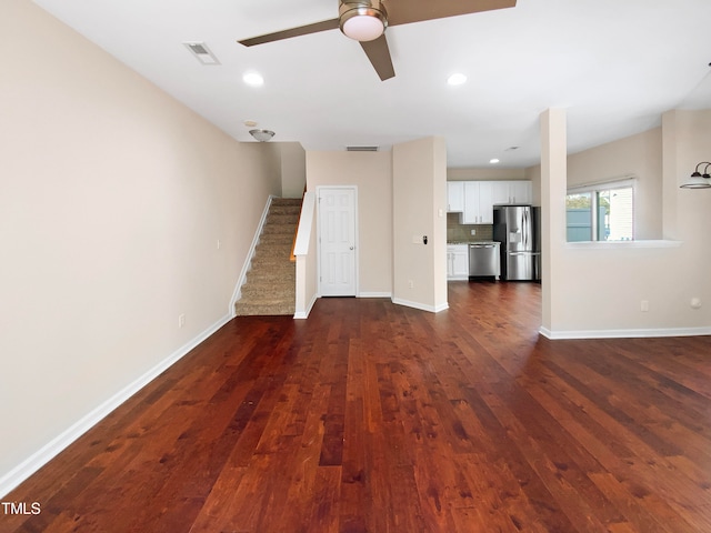 unfurnished living room featuring dark wood-type flooring and ceiling fan