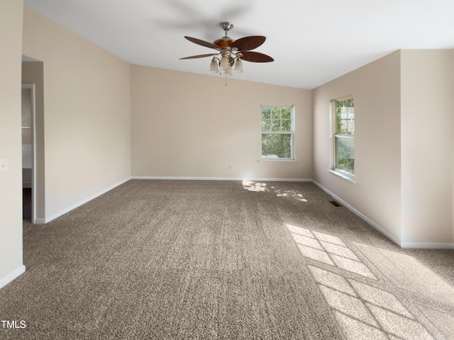 empty room featuring lofted ceiling, ceiling fan, and carpet floors