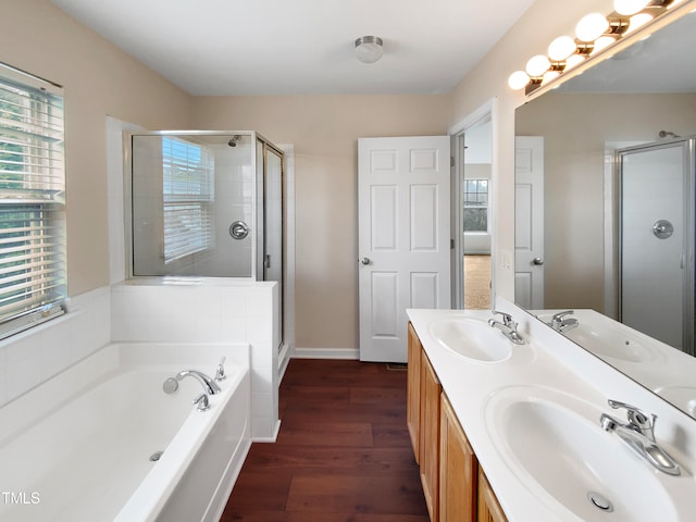 bathroom featuring wood-type flooring, shower with separate bathtub, and vanity