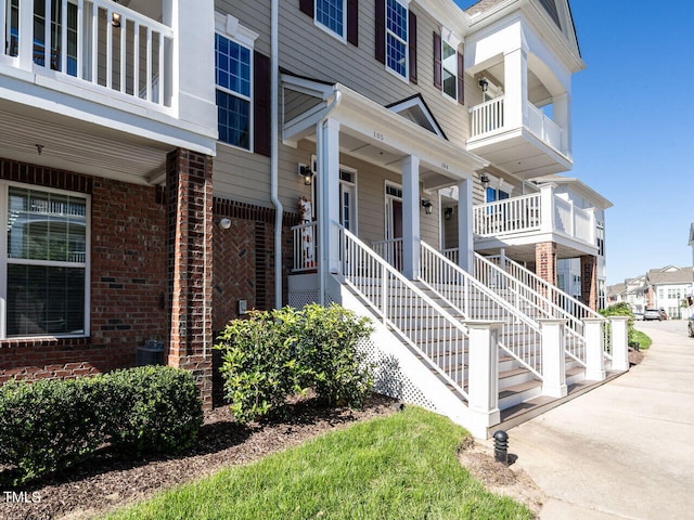 property entrance featuring covered porch and a balcony