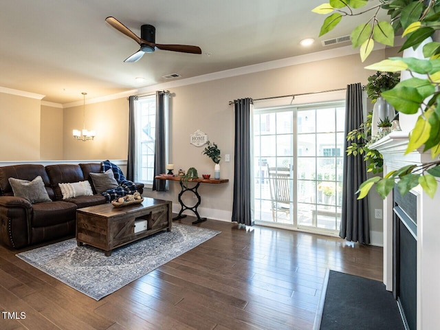 living room with a healthy amount of sunlight, crown molding, and dark hardwood / wood-style floors