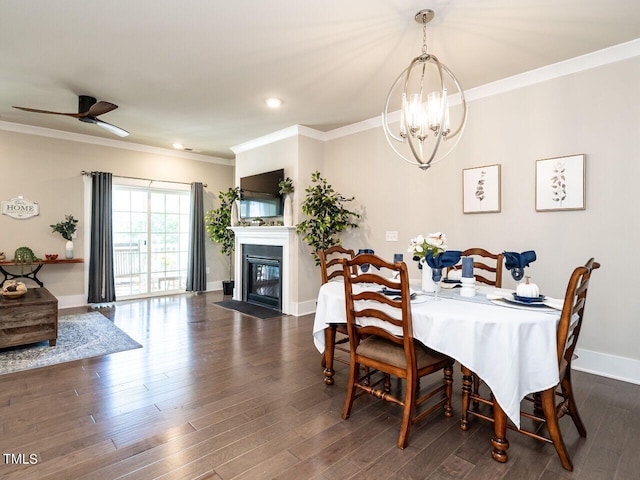 dining room featuring dark wood-type flooring, ceiling fan with notable chandelier, and crown molding