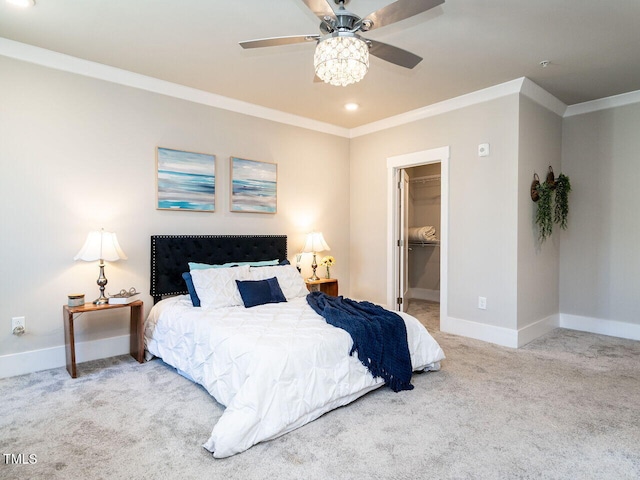 carpeted bedroom with ceiling fan, a closet, ornamental molding, and a spacious closet