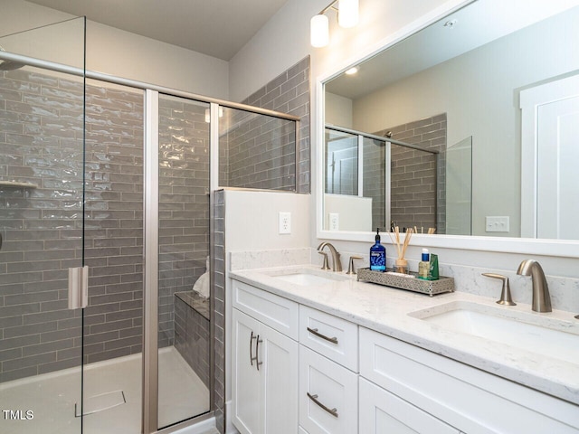 bathroom featuring a shower with door and vanity