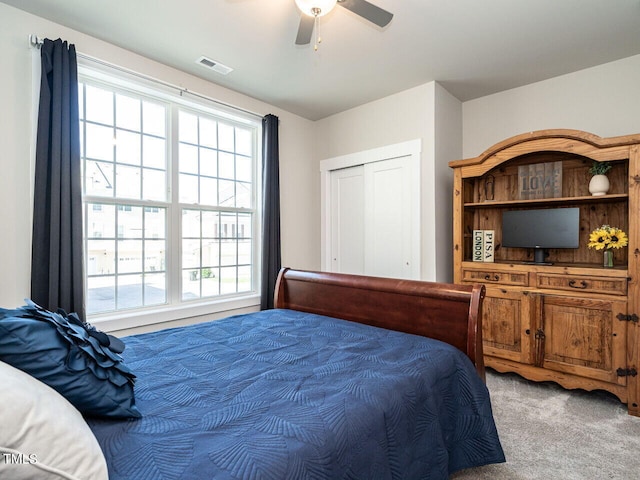 carpeted bedroom featuring a closet and ceiling fan