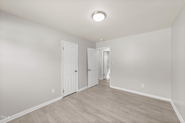 unfurnished bedroom featuring a textured ceiling and light hardwood / wood-style flooring