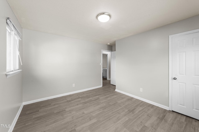 spare room featuring light hardwood / wood-style floors and a textured ceiling