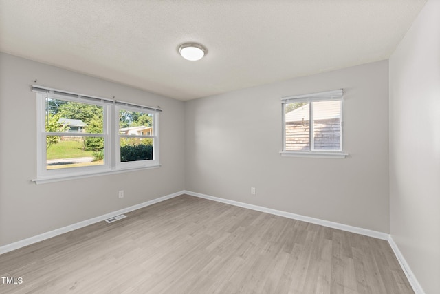 empty room featuring a textured ceiling and light wood-type flooring