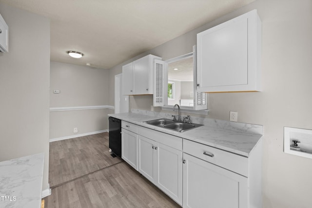 kitchen with white cabinets, light hardwood / wood-style flooring, sink, and light stone countertops