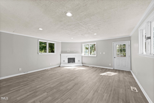 unfurnished living room with hardwood / wood-style flooring, crown molding, and a textured ceiling