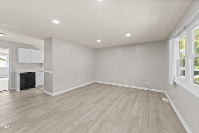 unfurnished living room with light hardwood / wood-style floors and a healthy amount of sunlight