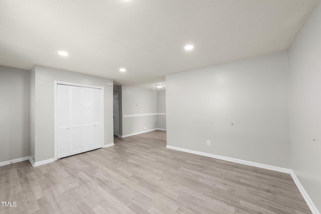 interior space featuring light wood-type flooring and a textured ceiling