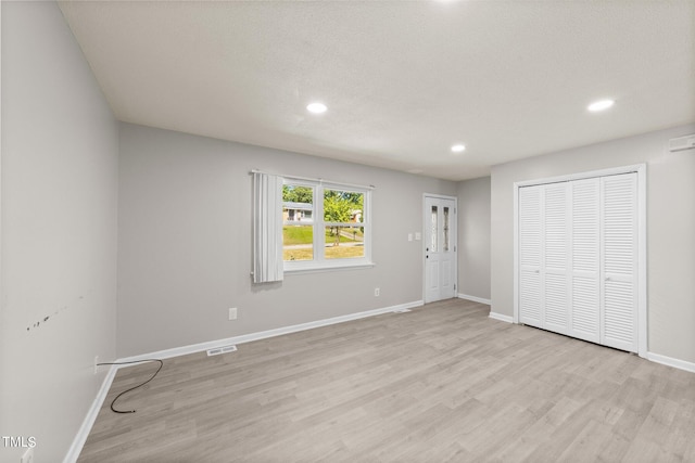 unfurnished bedroom featuring light hardwood / wood-style floors and a textured ceiling