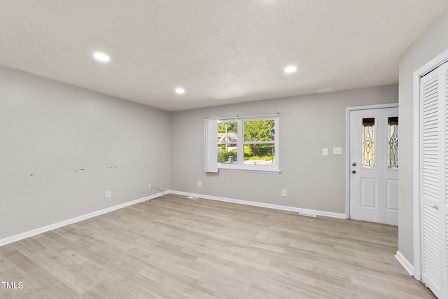 interior space with a textured ceiling and light wood-type flooring