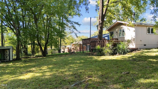 view of yard featuring a wooden deck and a shed