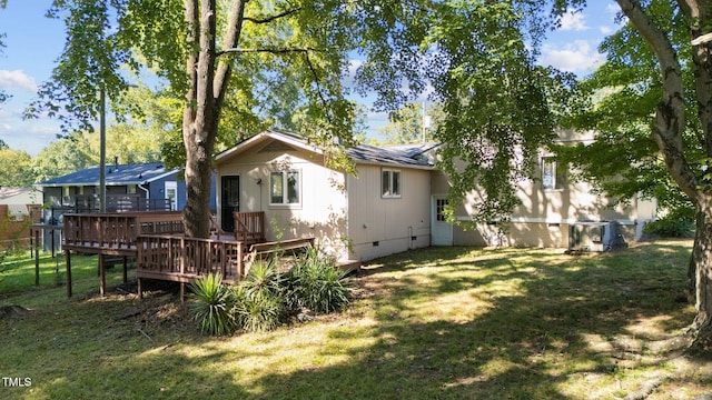 back of house with a deck and a lawn