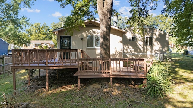 back of house featuring a deck and a lawn