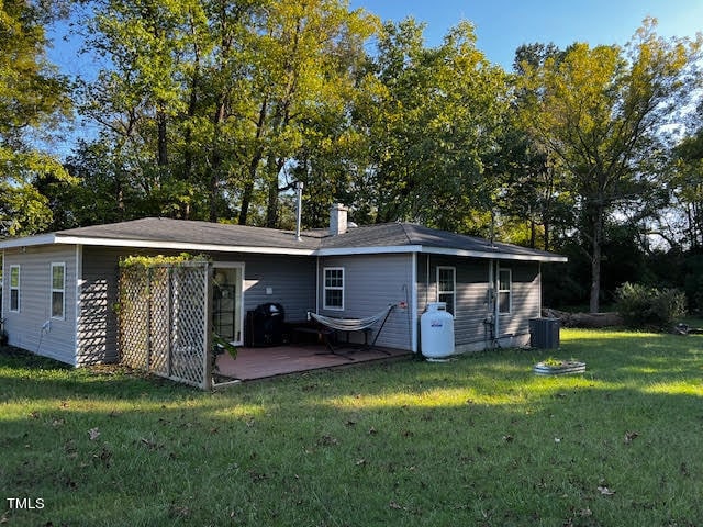 back of house featuring central AC unit, a patio area, and a yard