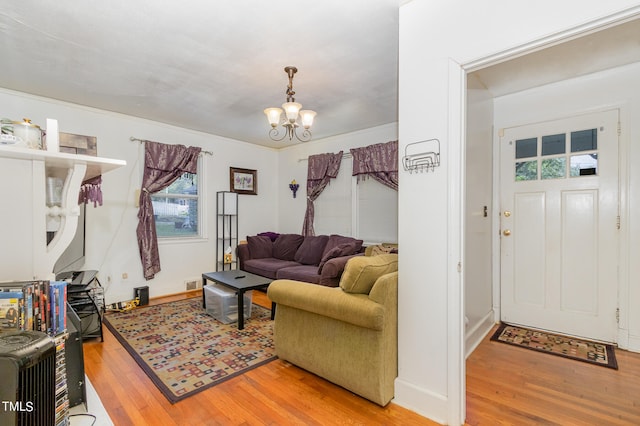 living room featuring an inviting chandelier and hardwood / wood-style flooring