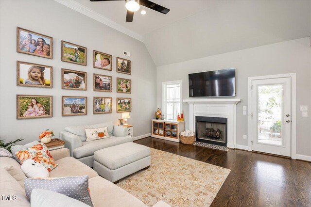 living room with ornamental molding, ceiling fan, vaulted ceiling, and dark hardwood / wood-style flooring