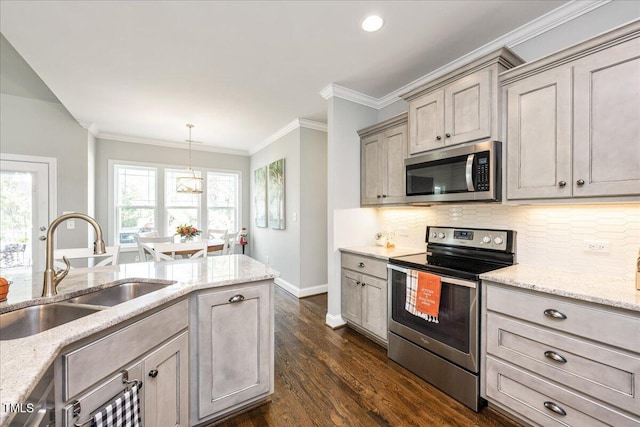 kitchen with sink, decorative light fixtures, dark wood-type flooring, appliances with stainless steel finishes, and light stone countertops