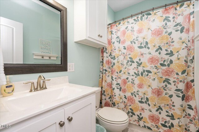 bathroom with vanity, toilet, and curtained shower