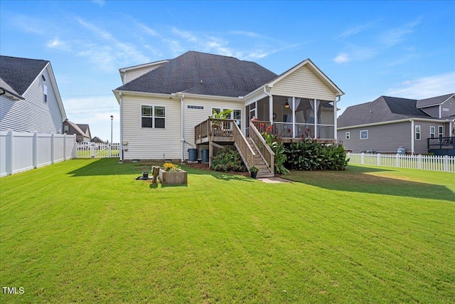 back of property featuring a yard, a sunroom, and a wooden deck