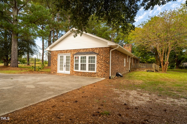 view of home's exterior featuring french doors and a lawn