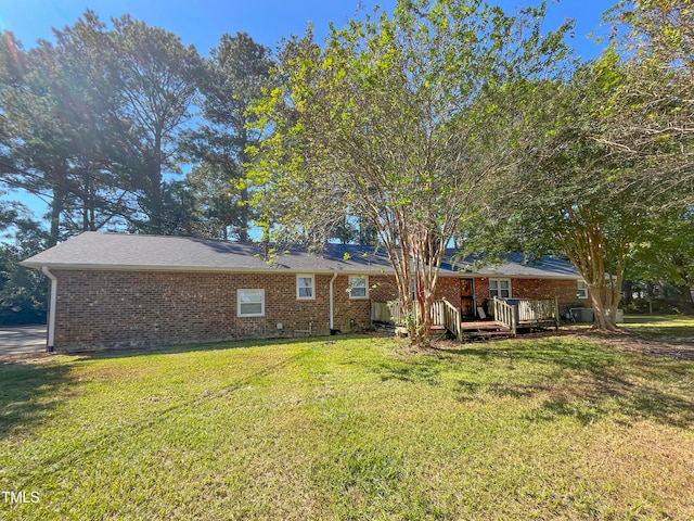 rear view of property with a yard and a wooden deck