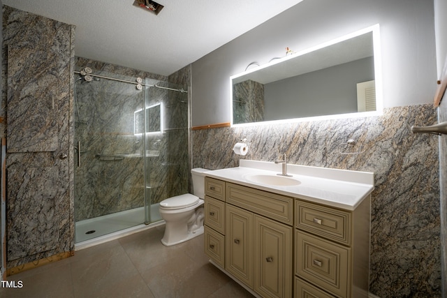 bathroom with toilet, tile walls, a shower with shower door, vanity, and a textured ceiling