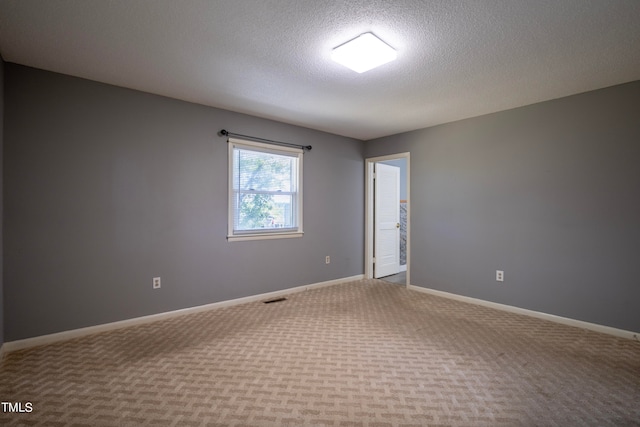 carpeted empty room with a textured ceiling