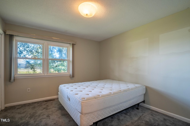 carpeted bedroom with a textured ceiling