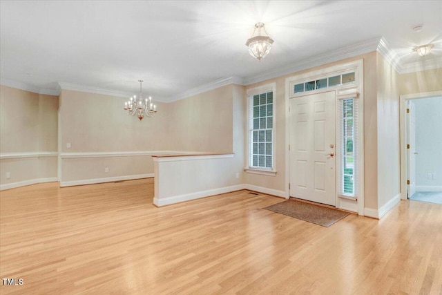 foyer entrance with ornamental molding, light hardwood / wood-style floors, and a chandelier