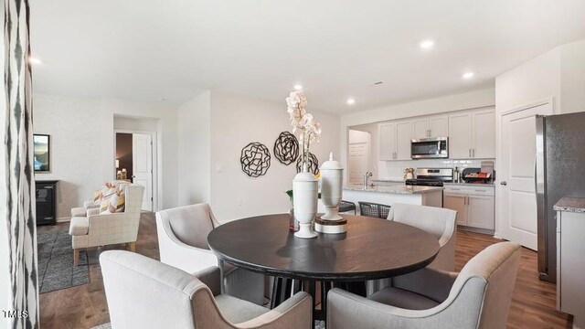 dining space with hardwood / wood-style floors and sink