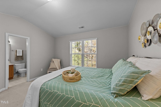 carpeted bedroom featuring connected bathroom and vaulted ceiling