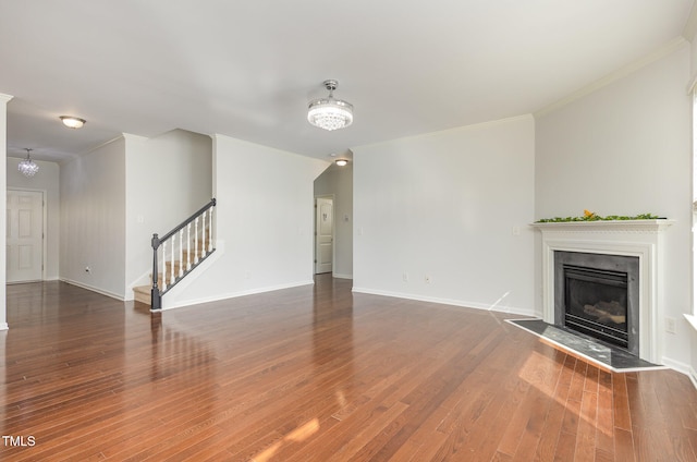 unfurnished living room with ornamental molding and dark hardwood / wood-style floors