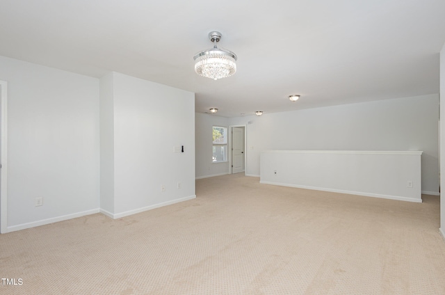 carpeted empty room featuring a chandelier