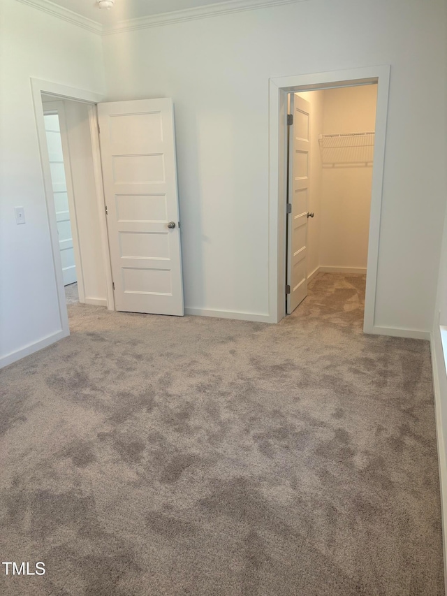 carpeted spare room featuring crown molding