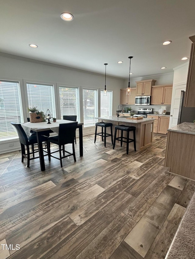 dining area with dark hardwood / wood-style floors, crown molding, and sink