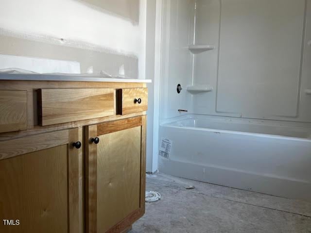 bathroom with bathtub / shower combination and concrete floors