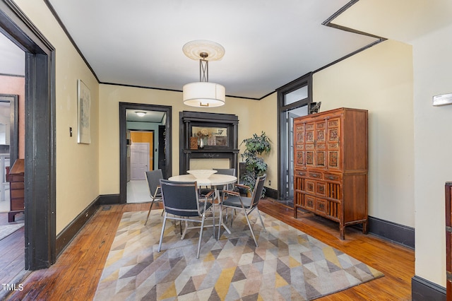 dining area with wood-type flooring and crown molding