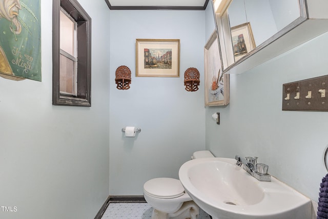 bathroom with crown molding, sink, and toilet