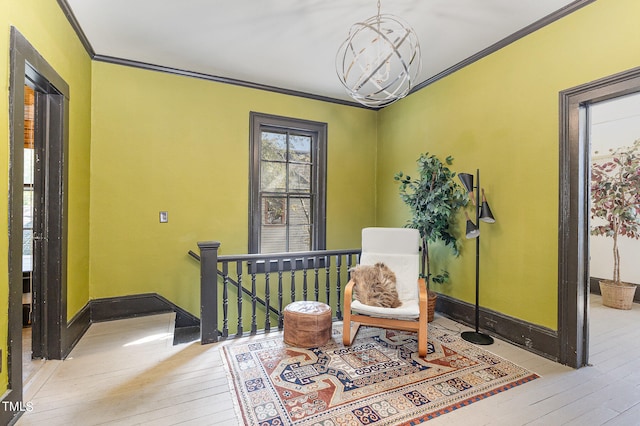 sitting room featuring ornamental molding, a chandelier, and light hardwood / wood-style flooring