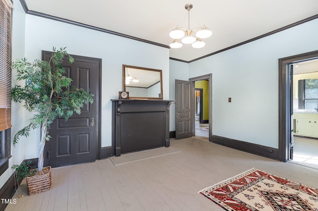 foyer entrance featuring ornamental molding, a chandelier, and light hardwood / wood-style flooring