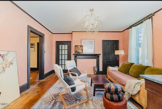 living room featuring wood-type flooring, an inviting chandelier, and ornamental molding