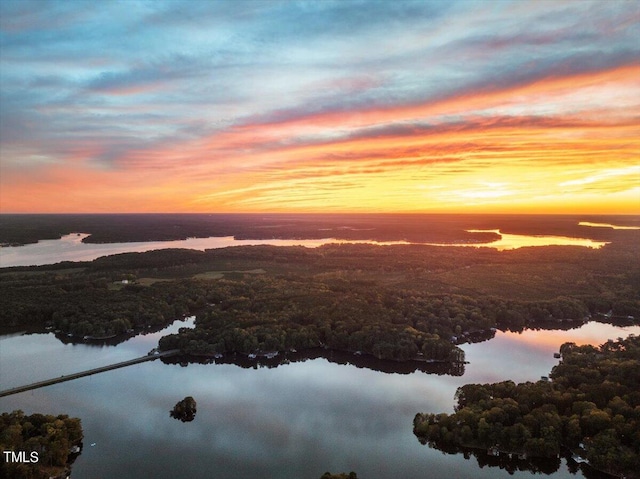 aerial view at dusk featuring a water view