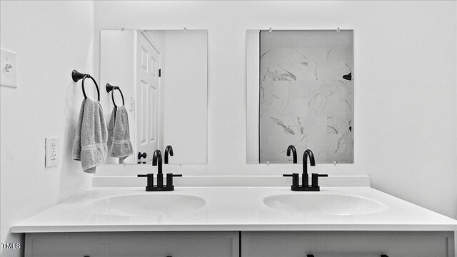 bathroom featuring a tile shower and vanity