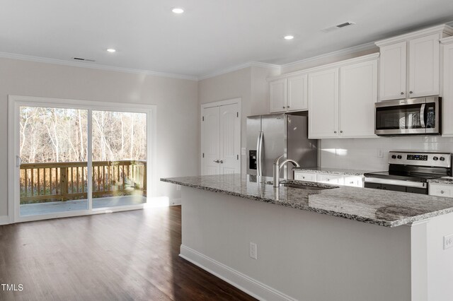 kitchen with appliances with stainless steel finishes, a kitchen island with sink, sink, white cabinets, and dark hardwood / wood-style floors